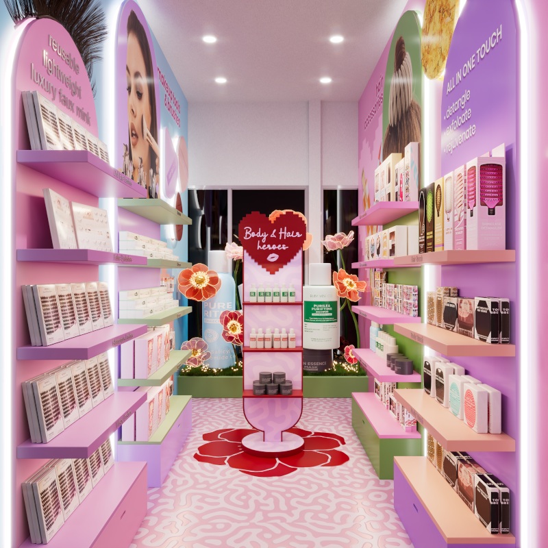 Ruby Vibe Co store aisle with pink shelves, beauty products, floral decor, and promotional signage.