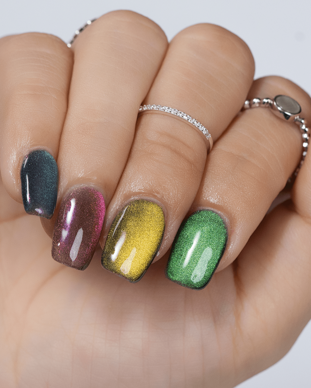 A close-up of a hand with a Cat-Eye gel nail design in multiple colors, showing the metallic shimmer effect and a popular gel nail trend.