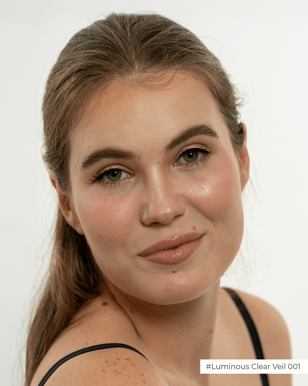 A close-up portrait of a woman with a natural, light complexion wearing a nude lipstick, a visual guide for finding the right nude lipstick shade for light skin.