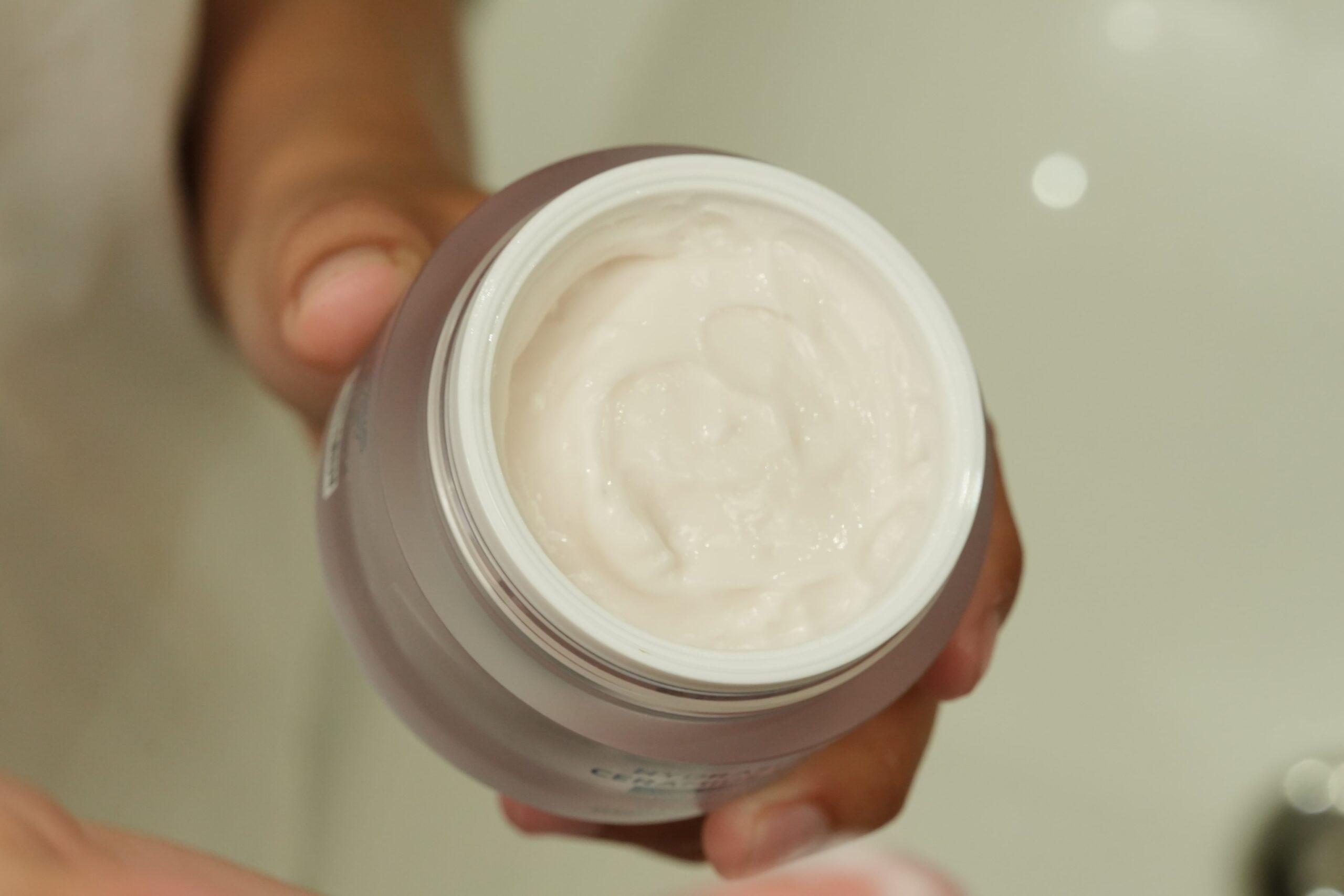 A close-up of a jar of 'Hydrashield Ceramide Cream,' a product for hydrating skin, which can be used in a retinol routine.