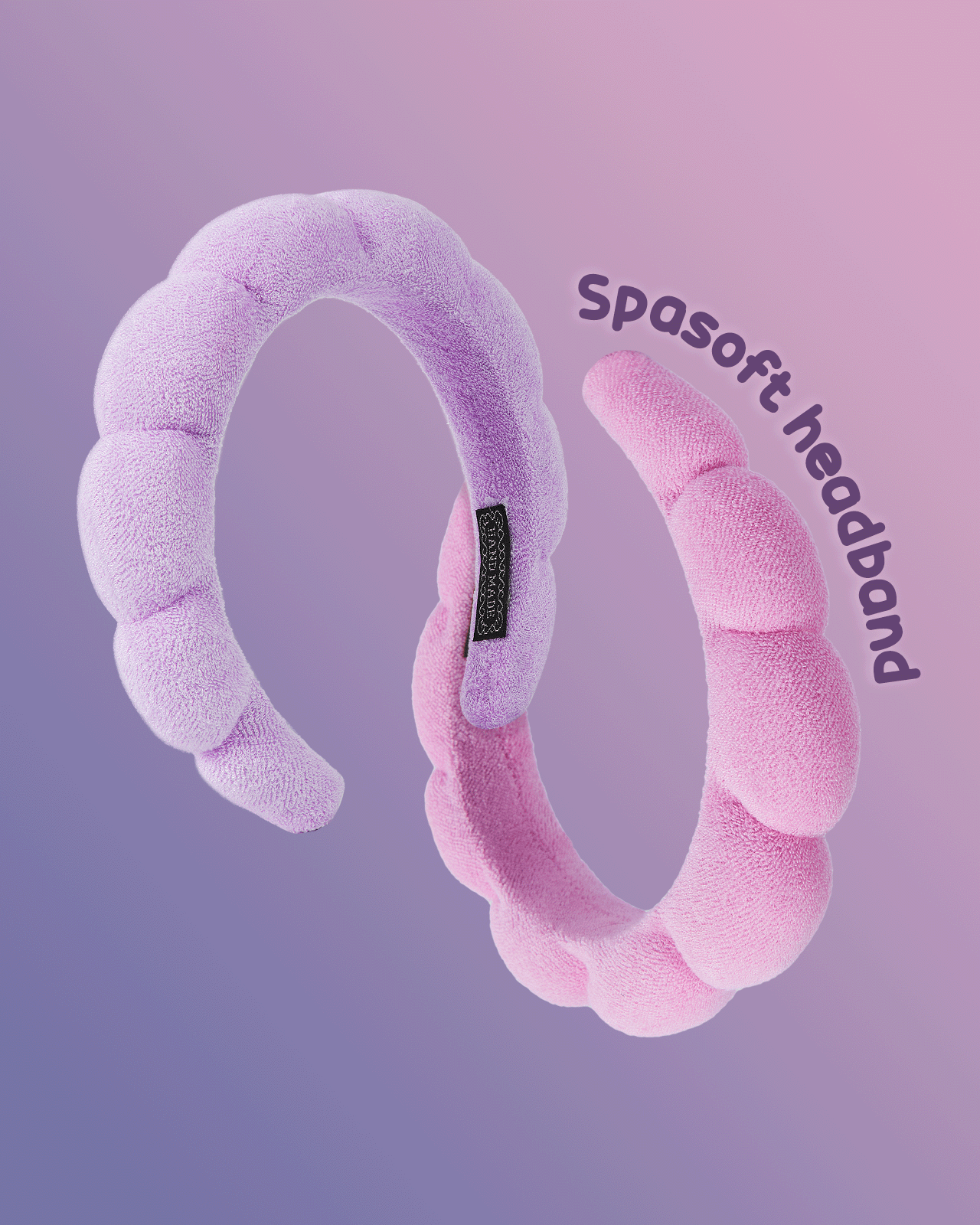 A product shot of two puffy 'Spasoft' headbands in pink and purple, showcasing different styles for a skincare routine.