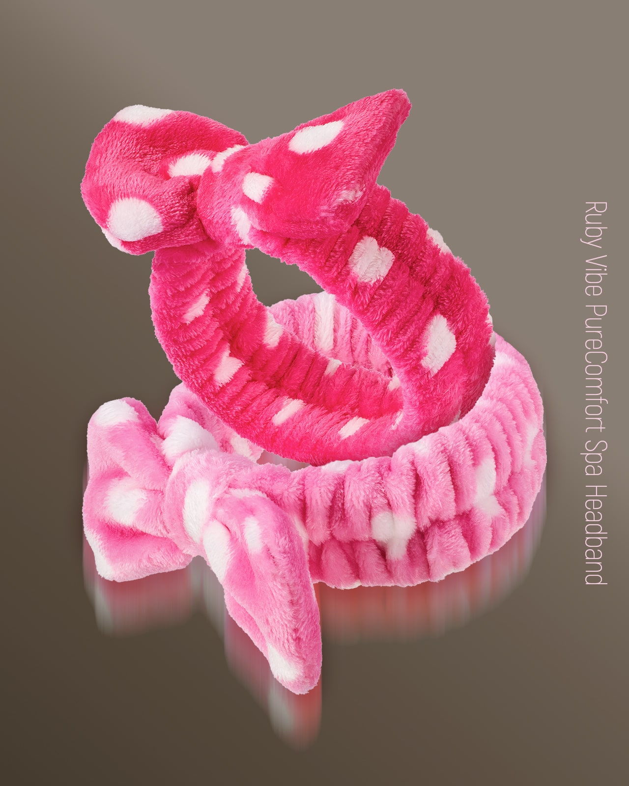 A product shot of two 'Ruby Vibe PureComfort Spa Headband' in pink and red, highlighting this must-have skincare accessory.