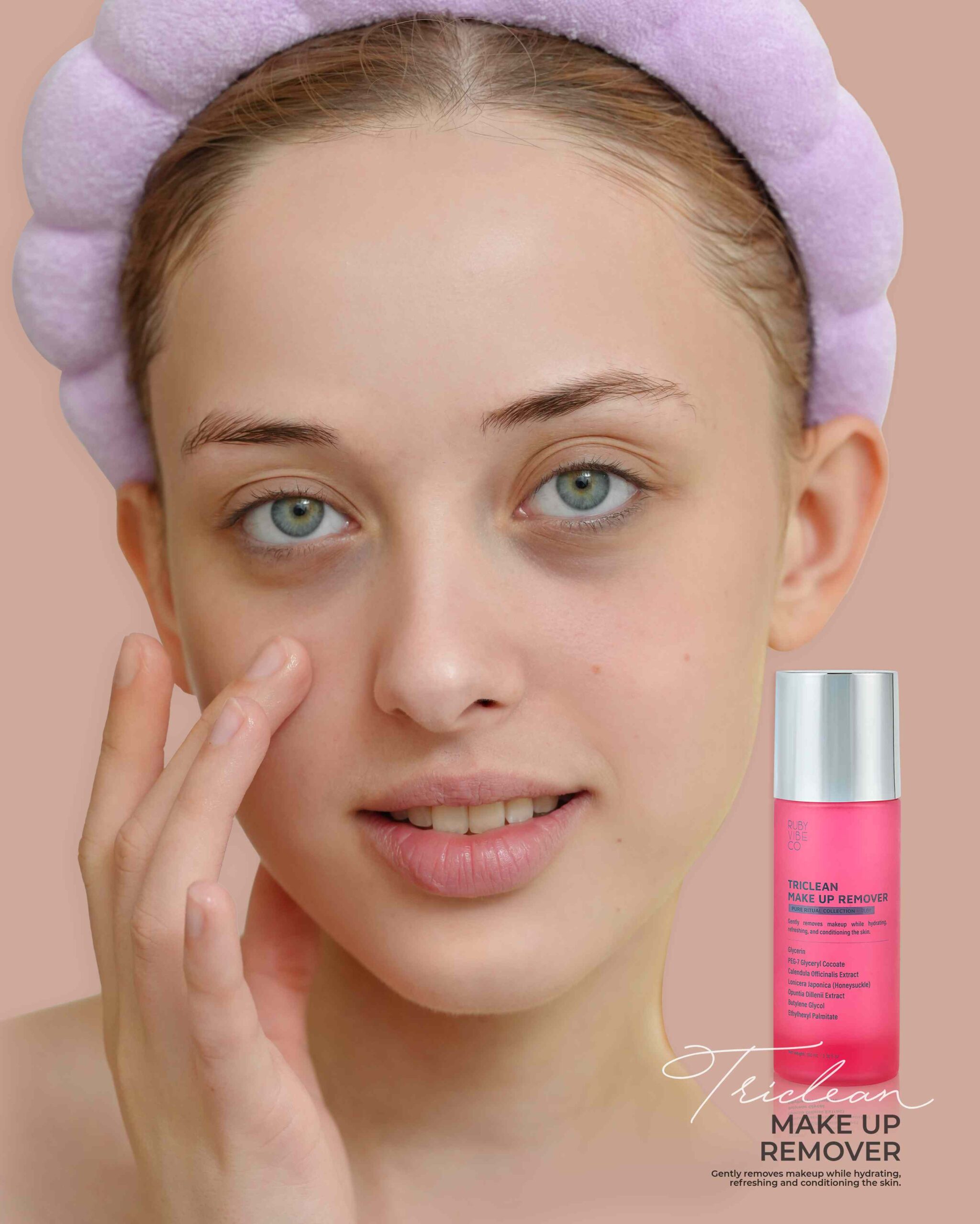 A young woman with a headband gently applies a pink 'Triclean Make Up Remover' to her face, emphasizing a gentle and safe routine for sensitive skin.