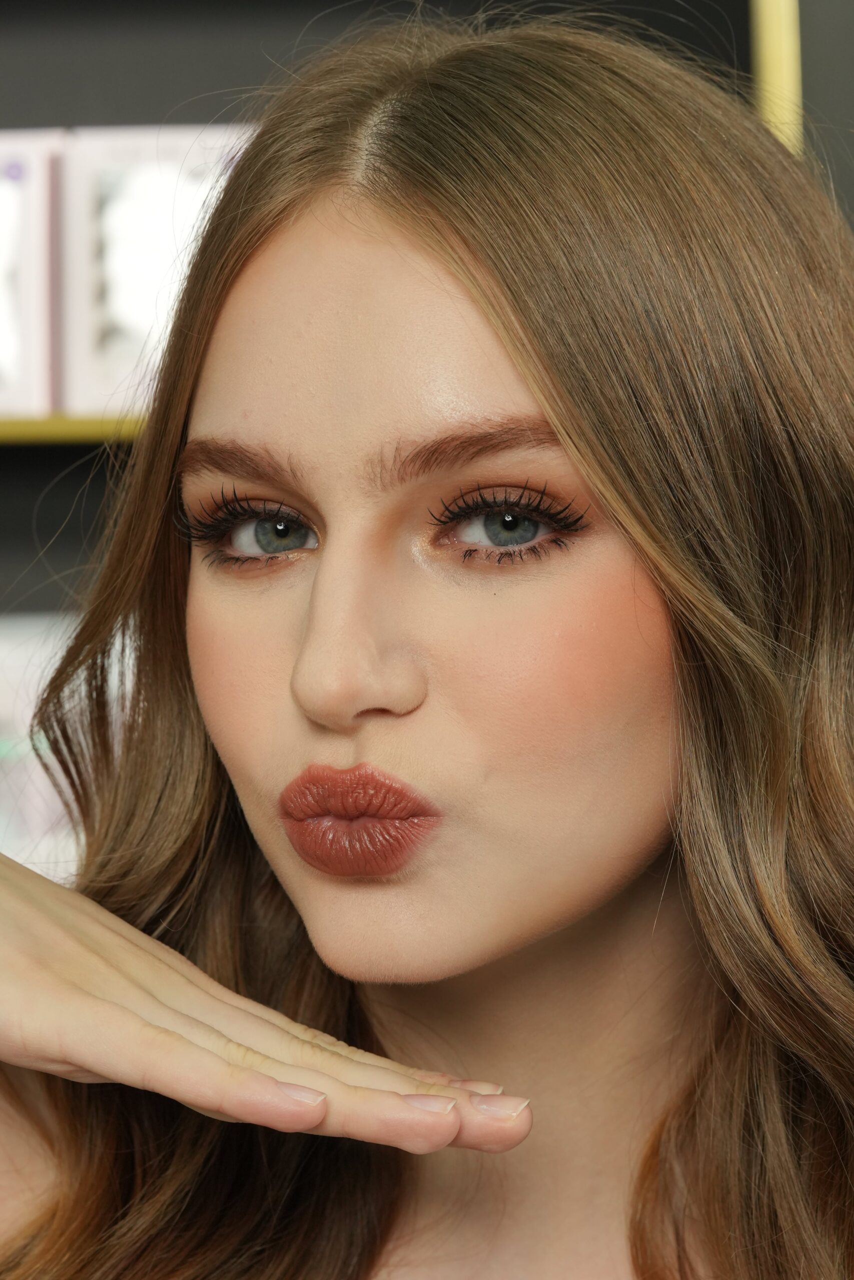 A close-up portrait of a woman with a natural makeup look and a matte nude lipstick, illustrating a chic and effortless style.