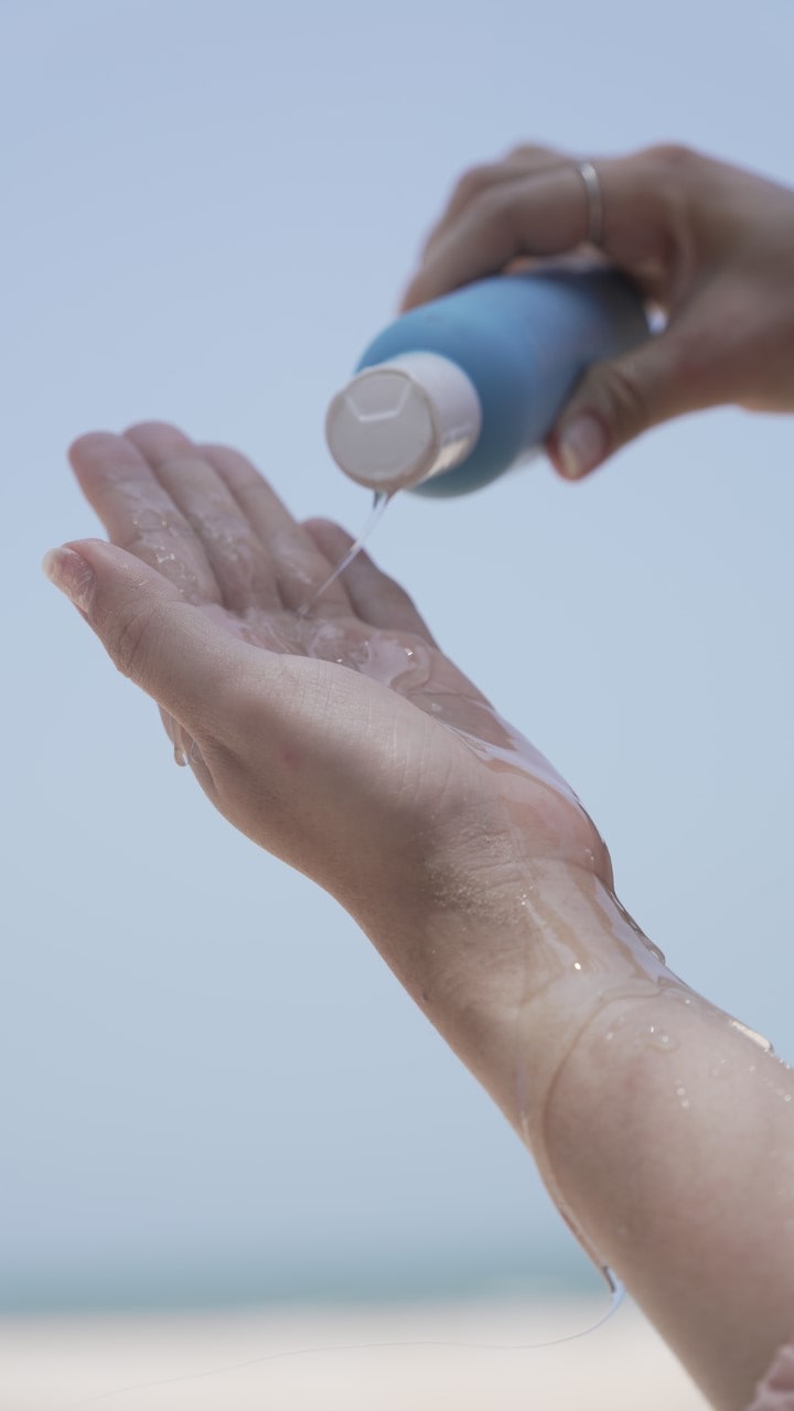 Close-up of a woman's hands massaging a rich body cream onto her smooth, hydrated legs