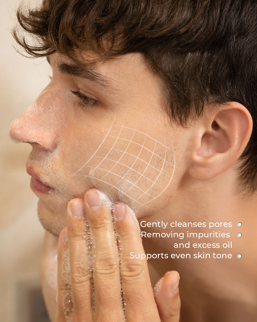 A close-up of a young man washing his face with a foaming cleanser, with a graphic illustrating the deep cleaning effect on his skin.