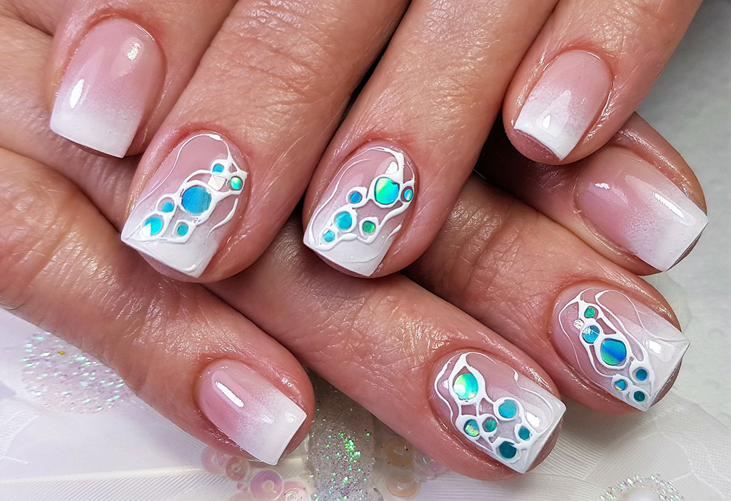 A vibrant nail art design with light blue ombre French tips, a chunky blue glitter nail