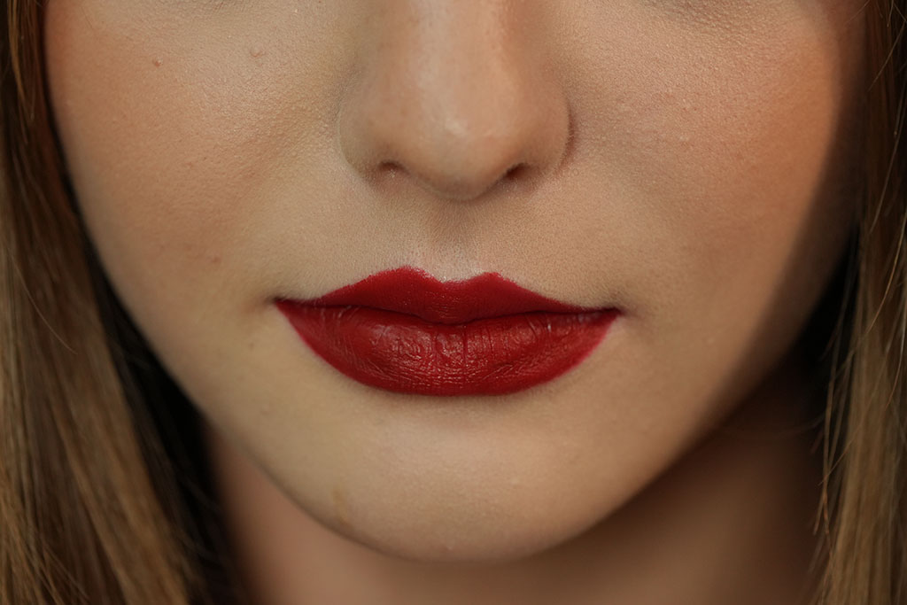 A close-up of a woman's lips with bold red lipstick.