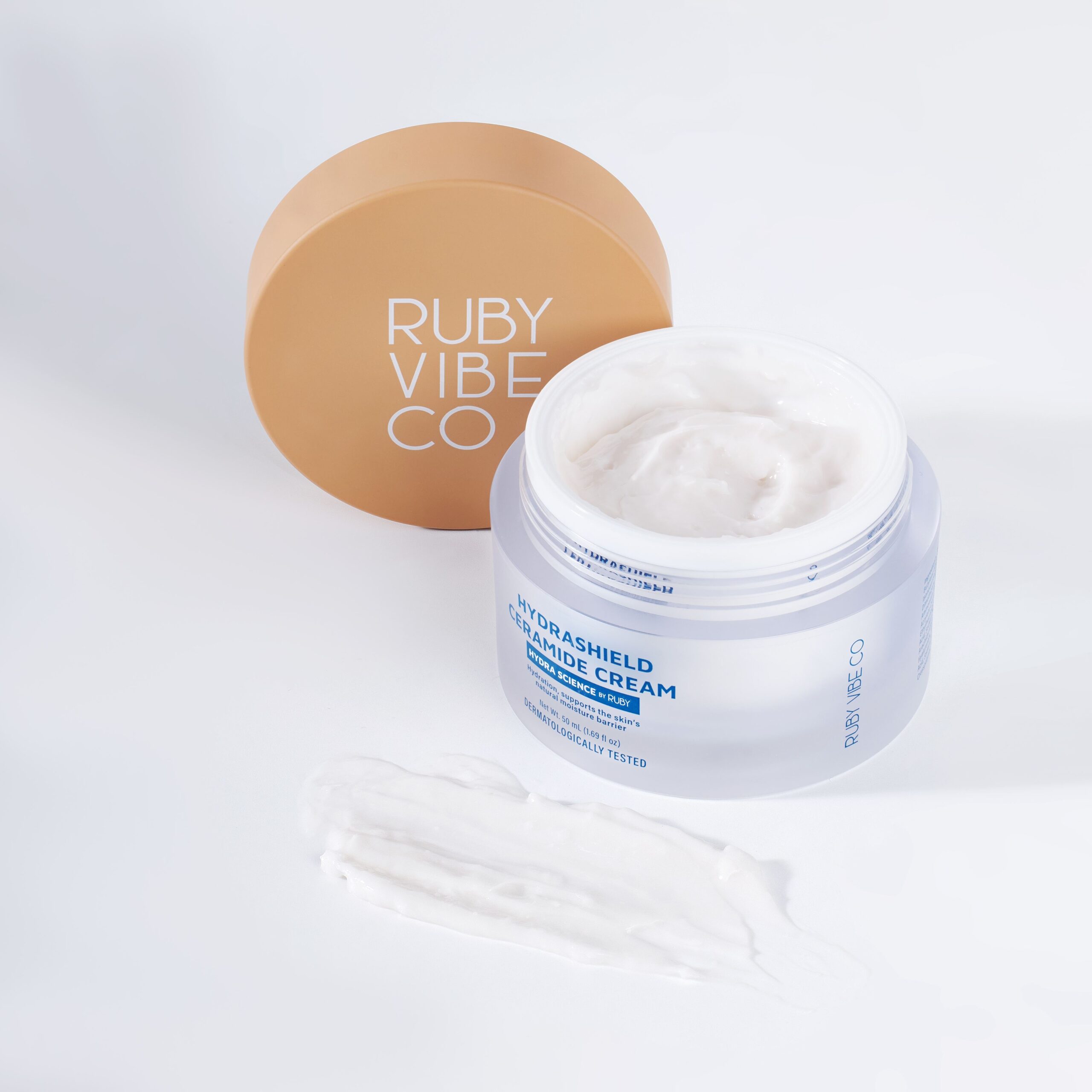 An open jar of Hydrashield Ceramide Cream next to a swatch of its texture, demonstrating the light, non-greasy consistency ideal for oily skin.