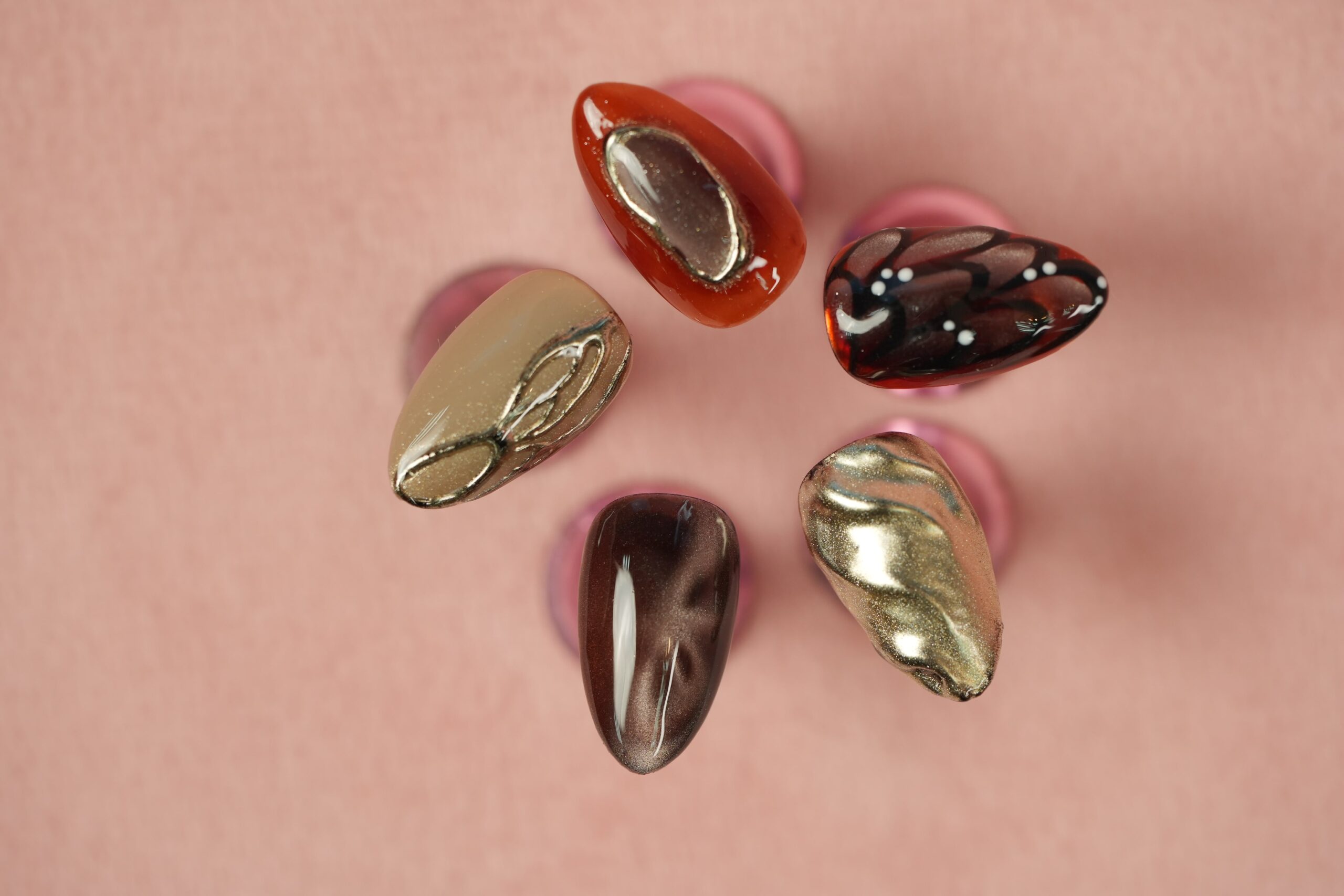 An elegant manicure idea combining solid nude-pink nails with a stunning gold chrome accent nail, a simple yet creative chrome nail design.