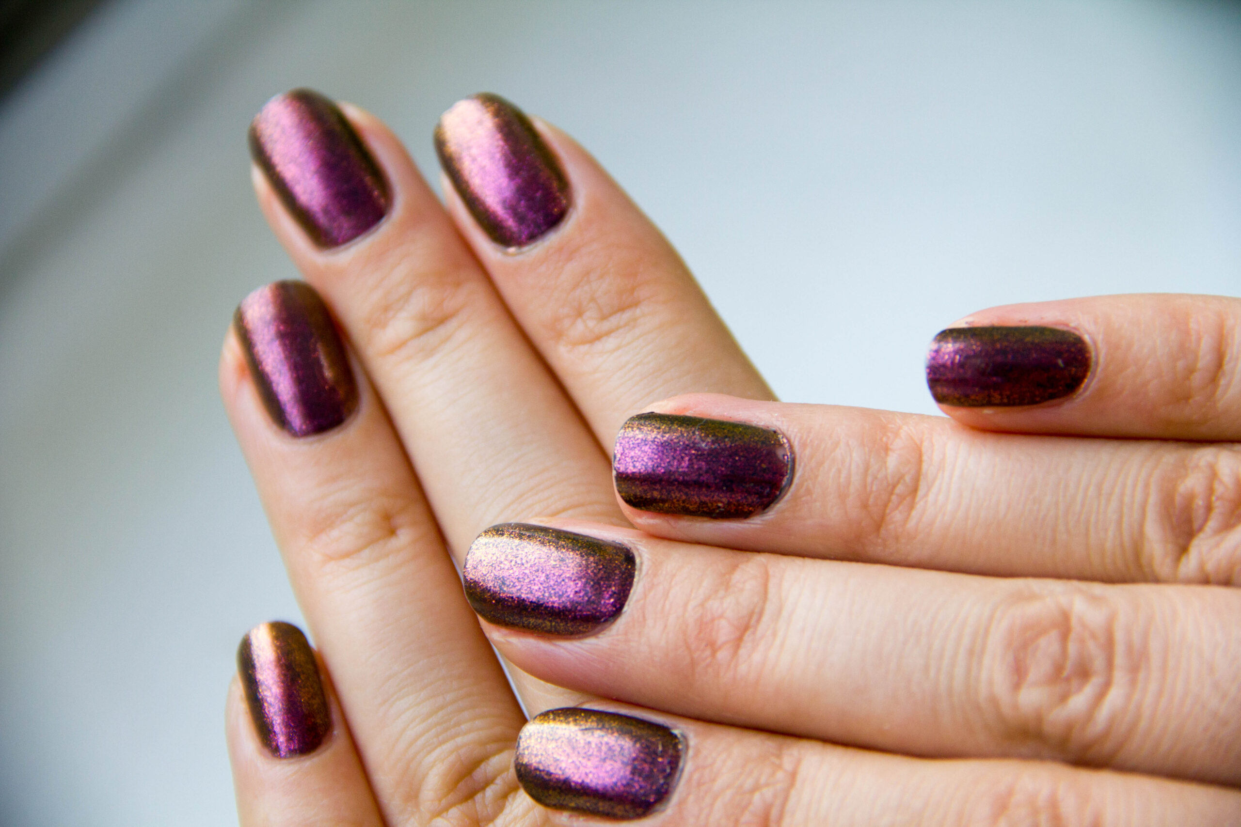  A chic and subtle chrome nail design featuring a pearlescent 'glazed donut' base with delicate, thin gold chrome French tips for an elegant manicure.