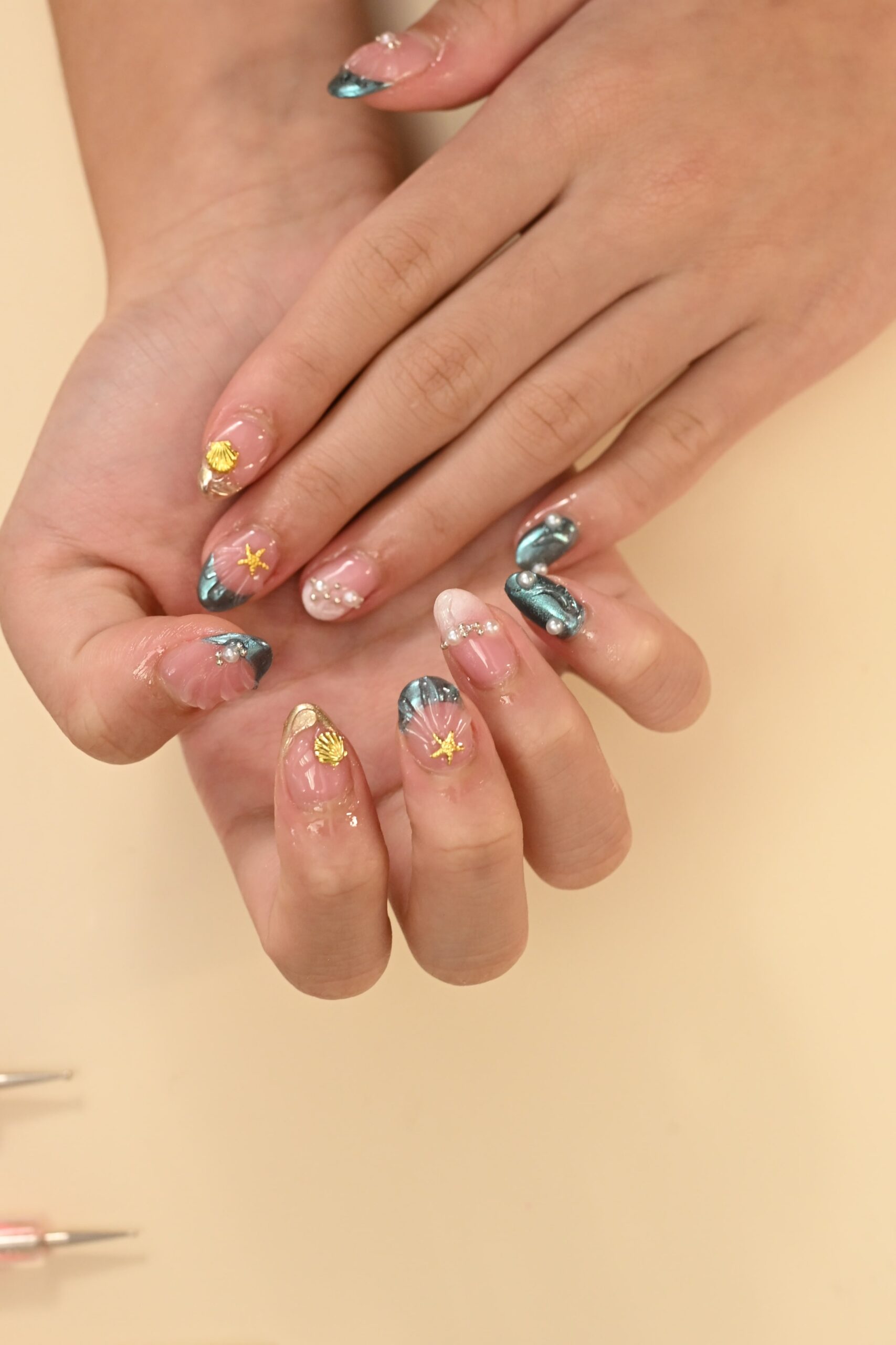 A direct comparison to help choose a finish: a nail with a smooth, mirror-like chrome finish next to a nail with a sparkling, rainbow-reflecting holo finish.