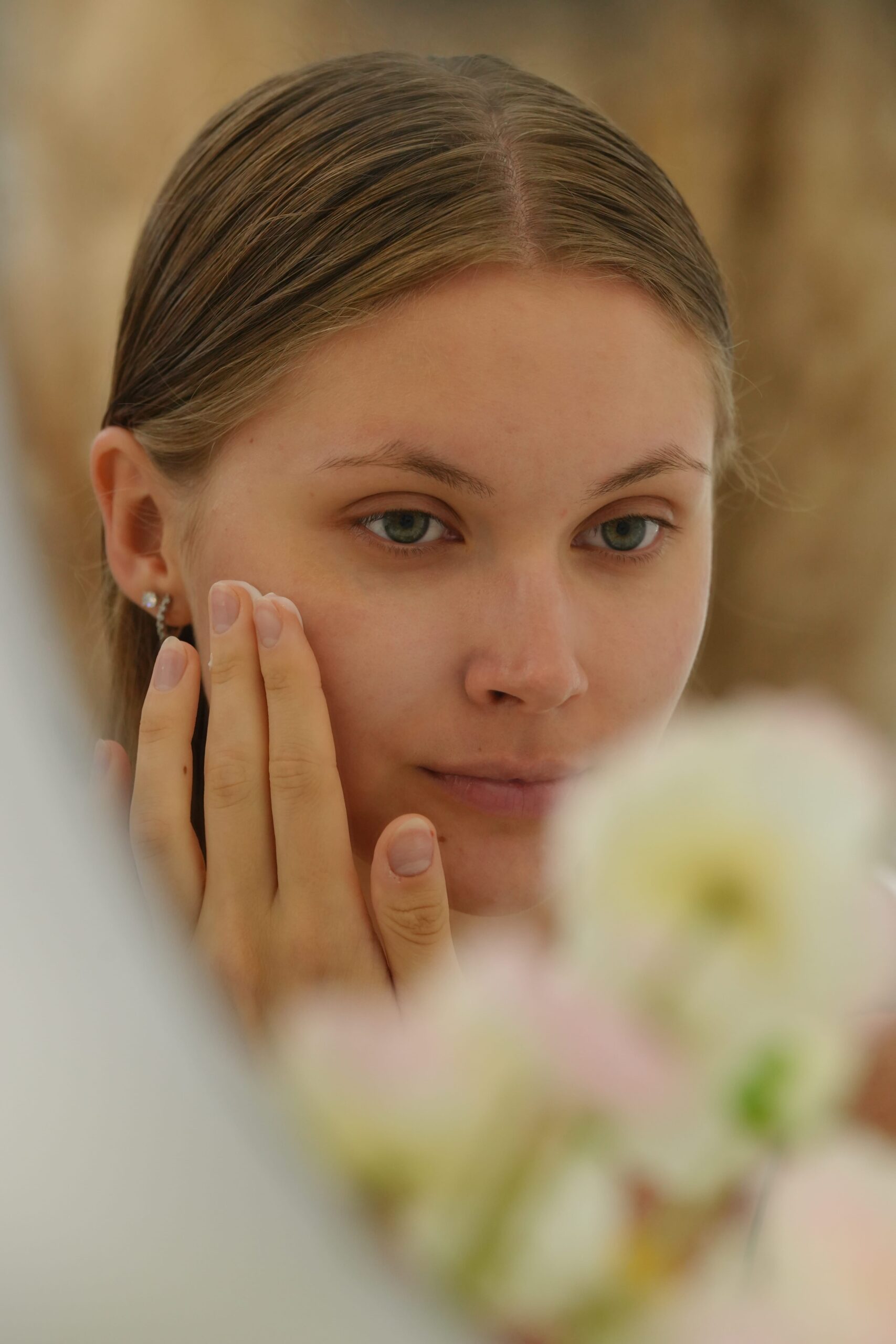 A person gently pats a product around her eye area with her finger, showing the proper technique for applying eye cream or concealer to conceal dark circles.