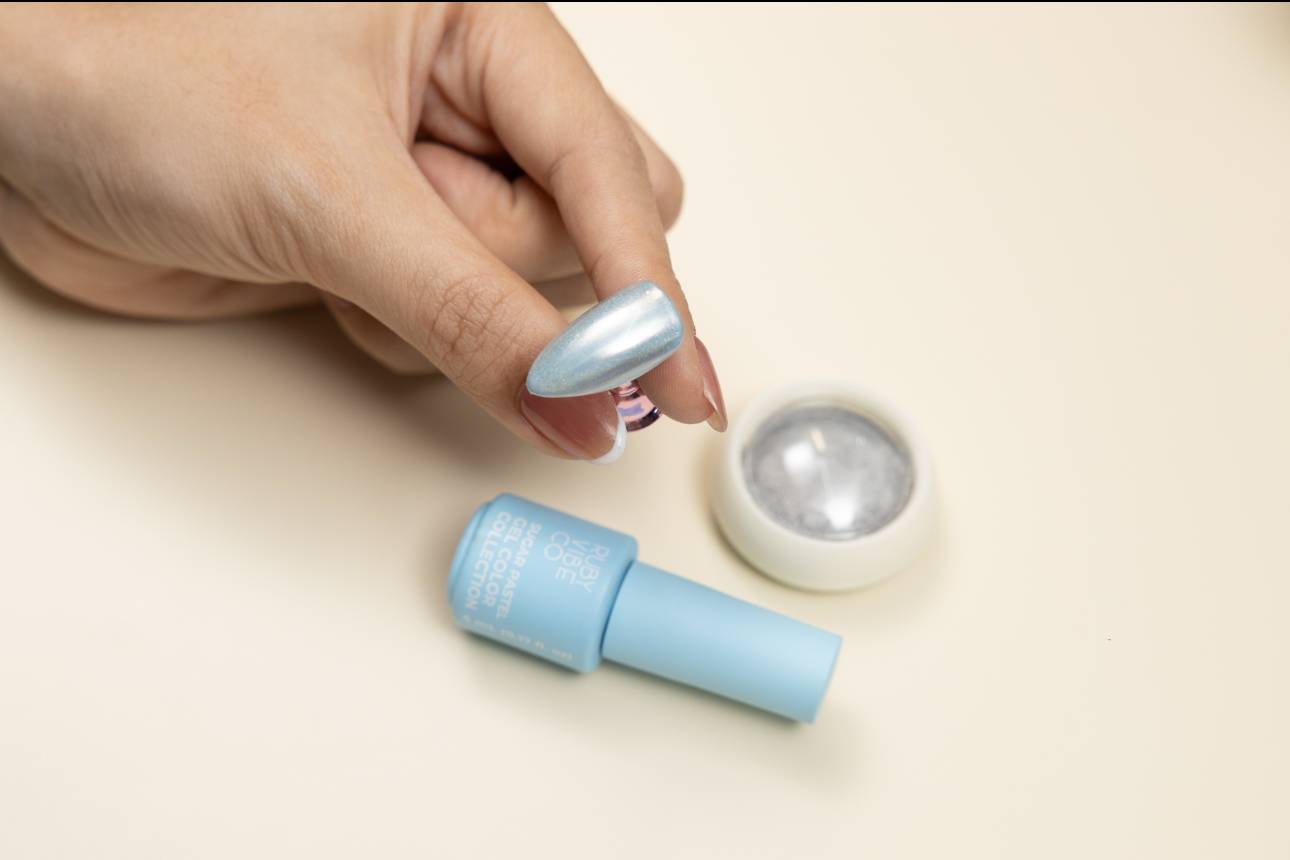 DIY chrome nails: A finished fake nail with shimmering blue chrome powder, ready for top coat.