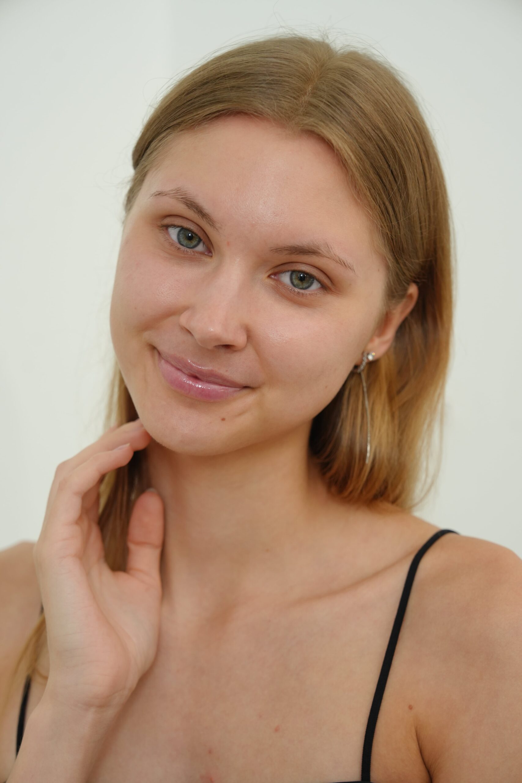 A portrait of a woman with a confident smile and healthy-looking hair and skin, representing the positive results of a successful hair loss treatment routine.